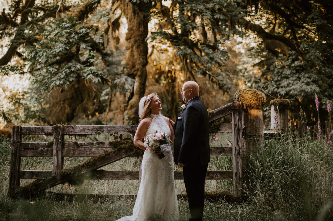 Couple laughing by a moss covered gate near La Push in Olympic National Park during a Washington elopement