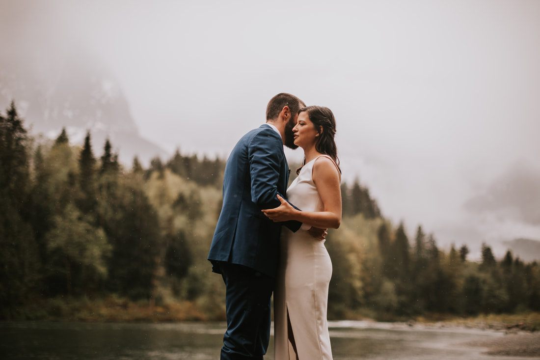Bride and groom holding hands beside the lake at their PNW cabin elopement