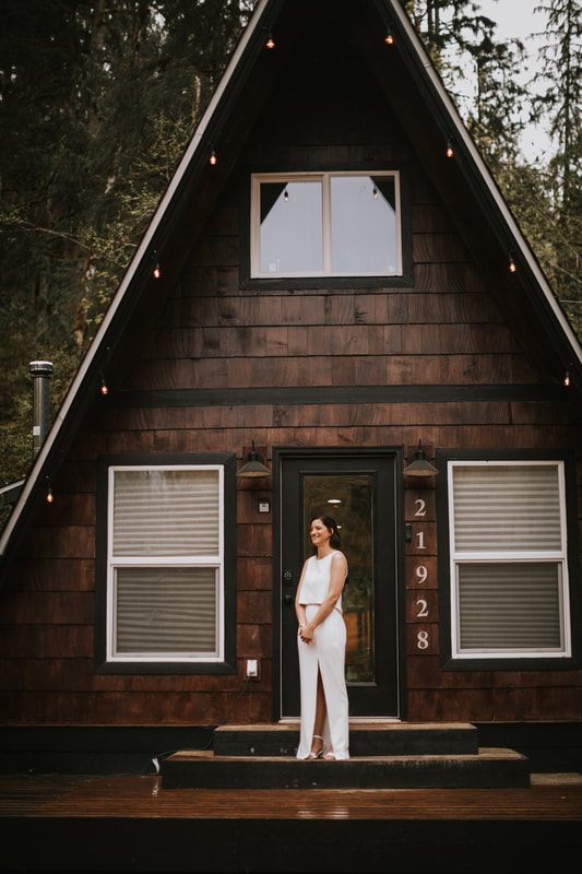 Bride and groom laughing together inside the greenhouse by the creek