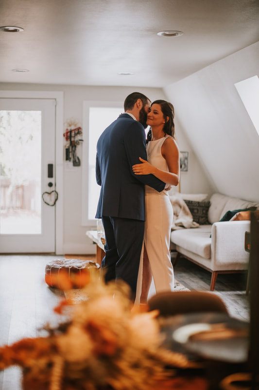 Groom helping his bride through the woods near the elopement cabin