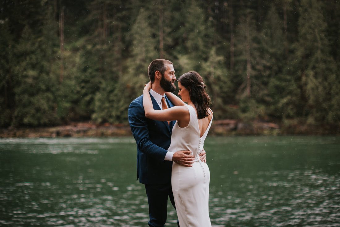 Wide shot of the couple standing on the dock overlooking the lake