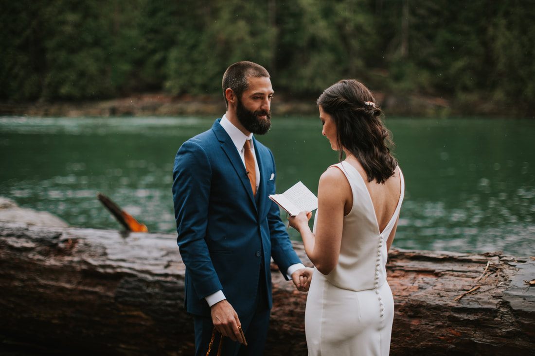 Bride and groom laughing together inside the greenhouse by the creek