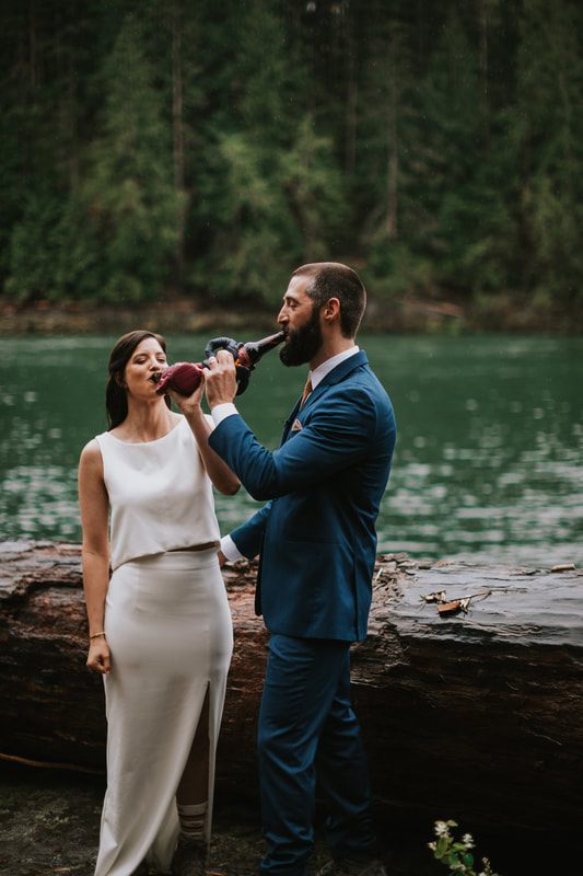 Groom helping his bride through the woods near the elopement cabin