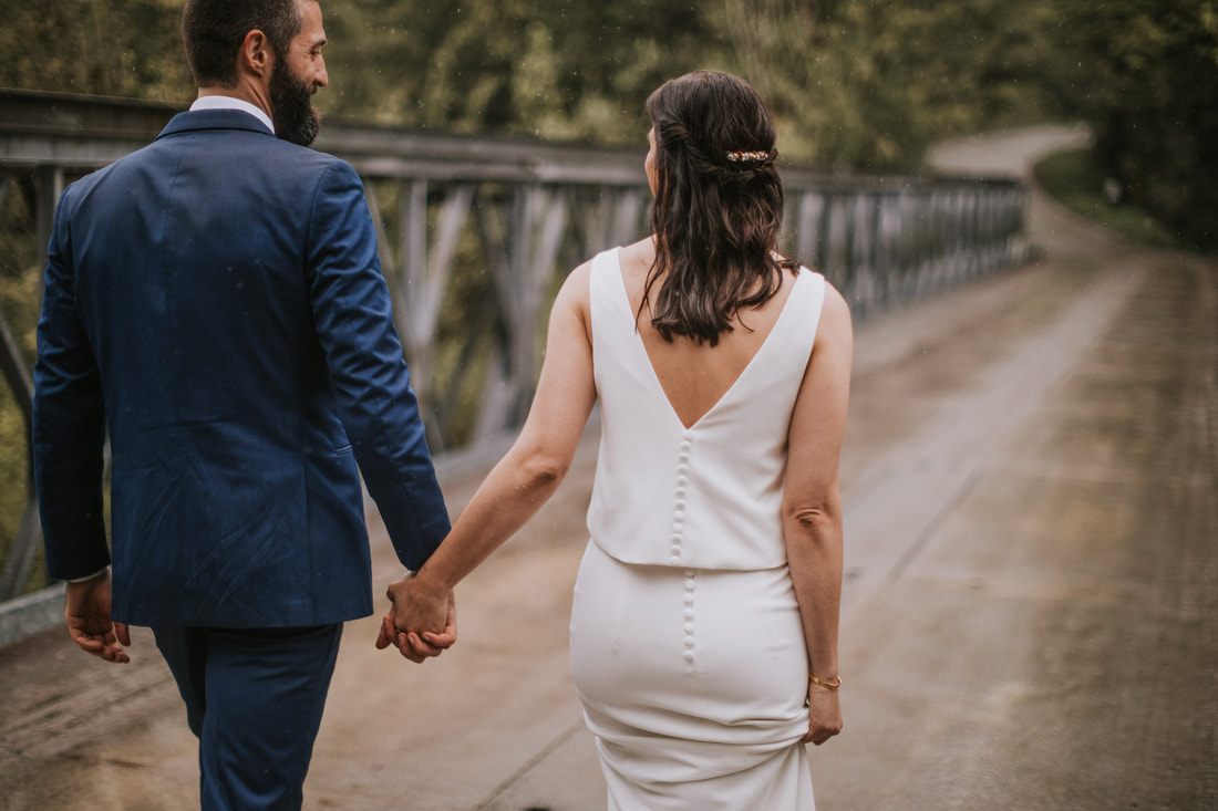 Wide shot of the couple standing on the dock overlooking the lake