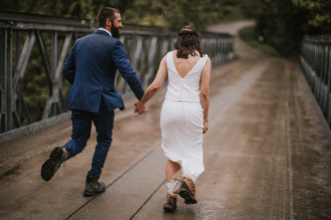 Bride twirling in her wedding dress near the mountain lake
