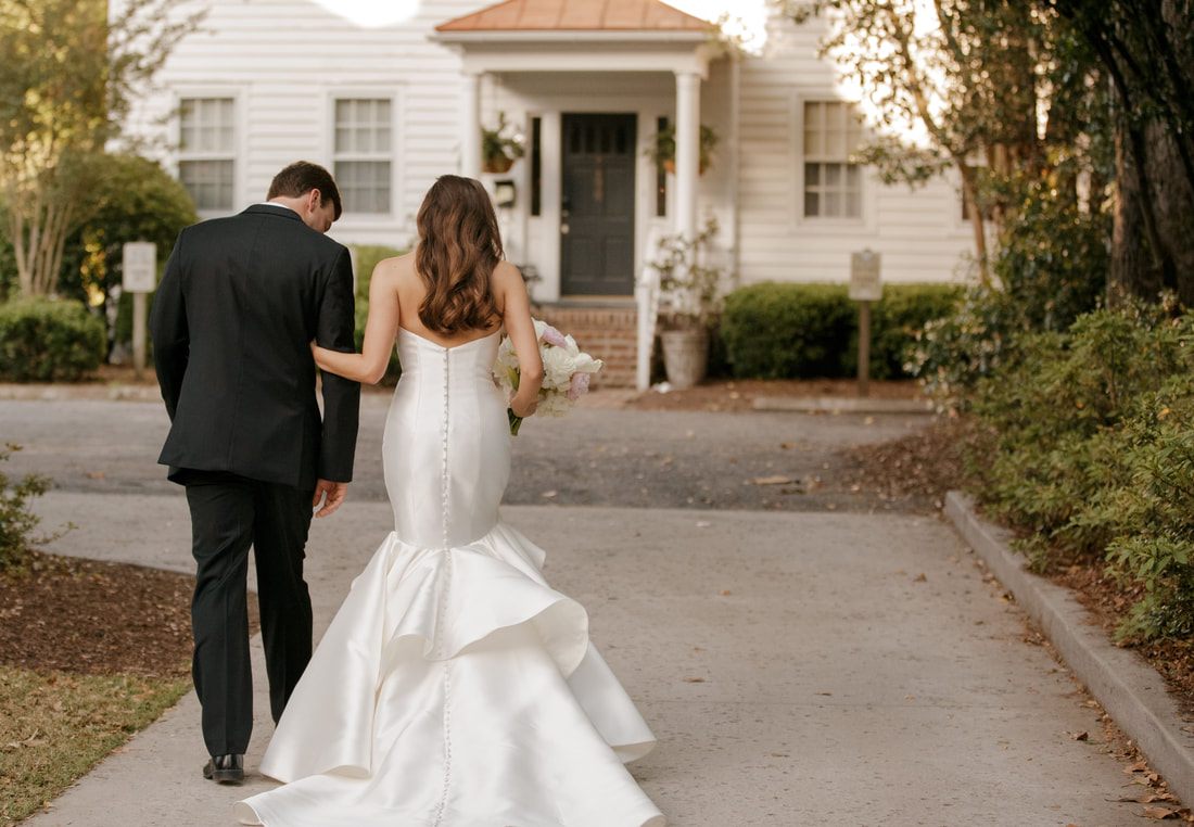 Tyler and Emily walking hand in hand through downtown Charleston