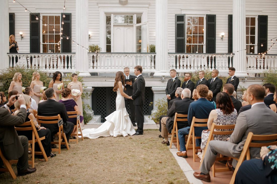 Groom and groomsmen posing on a colorful Charleston side street