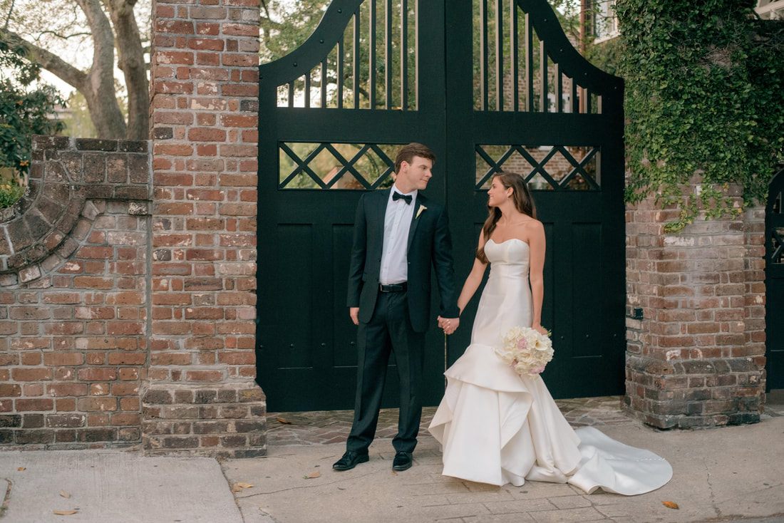 Tyler and Emily walking hand in hand through downtown Charleston