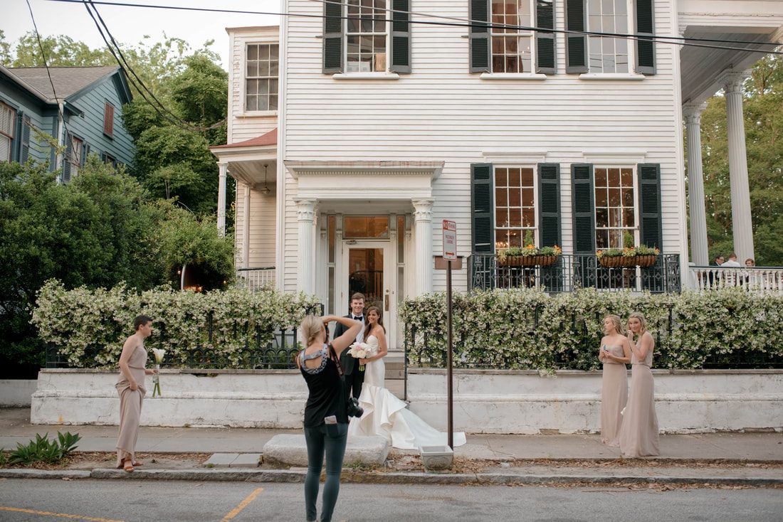 Groom and groomsmen posing on a colorful Charleston side street