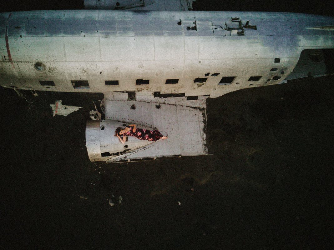 Drone shot showing the plane wreck and black sand beach from above