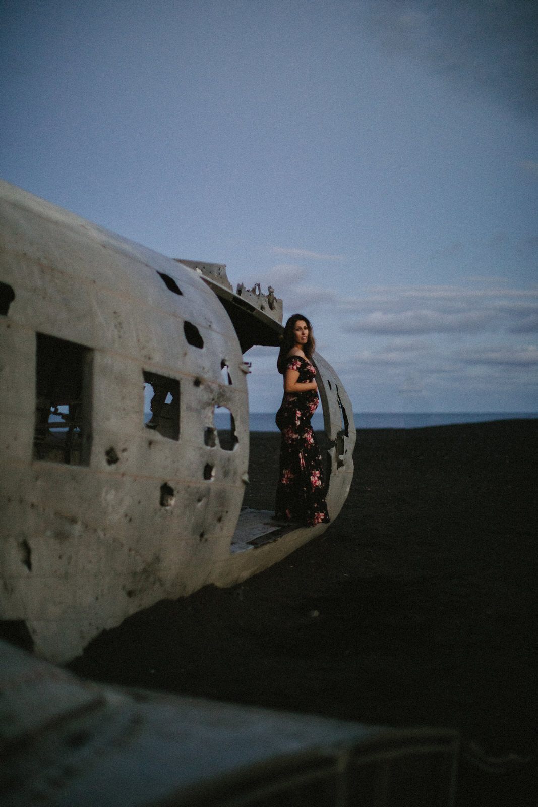 Pregnant woman walking along the black sand beach at 2 a.m. in Iceland