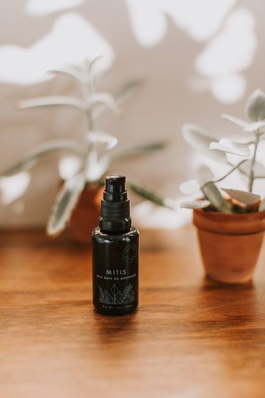 Skincare jar and dropper bottle photographed with soft natural light.