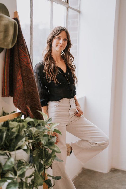 Celeste sits thoughtfully for a branding photo highlighting her work as a spiritual coach.