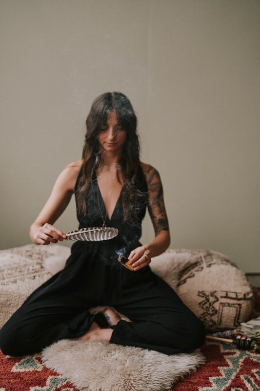 Celeste sits thoughtfully for a branding photo highlighting her work as a spiritual coach.