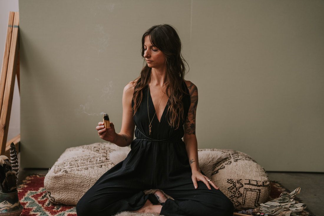 Celeste poses with a potted plant, reflecting her work as a spiritual plant guide.
