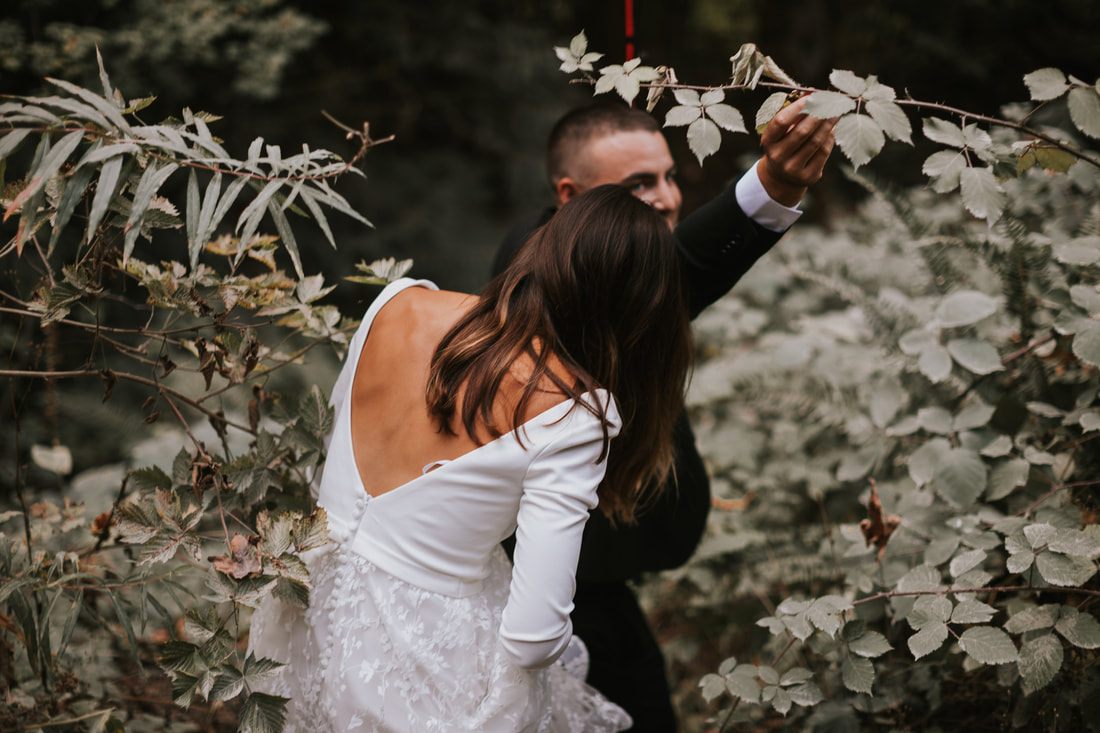 Close-up portrait of the newlyweds smiling in the forest light