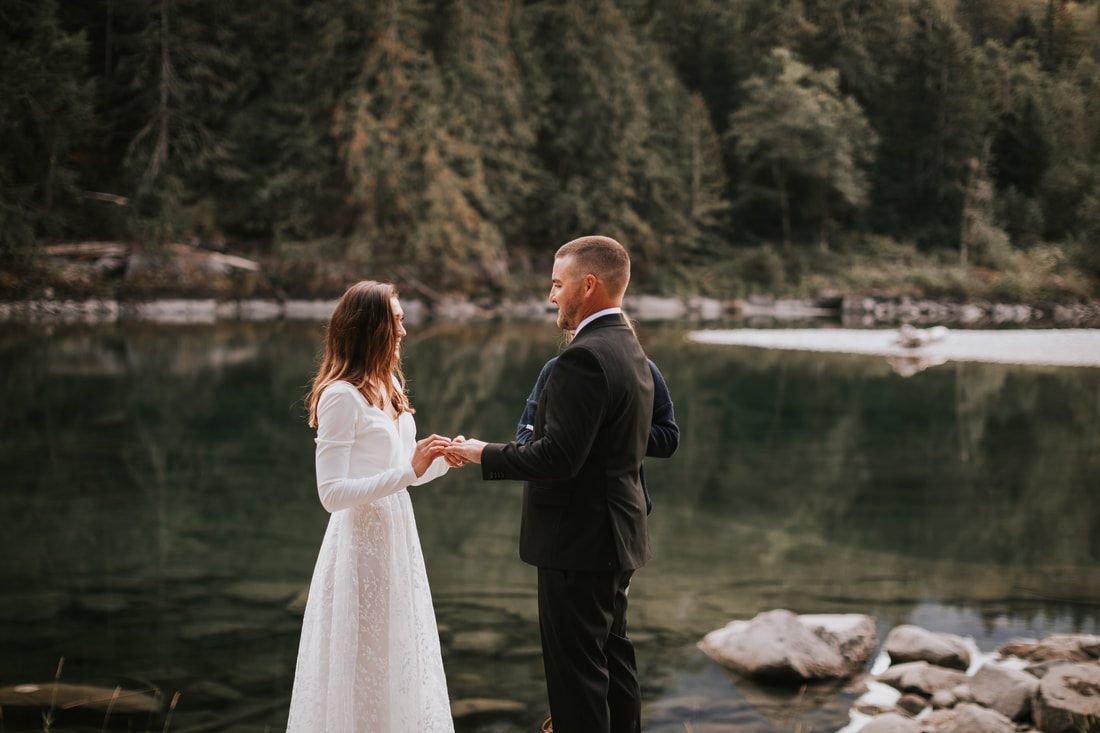 The couple laughing together while walking through the woods