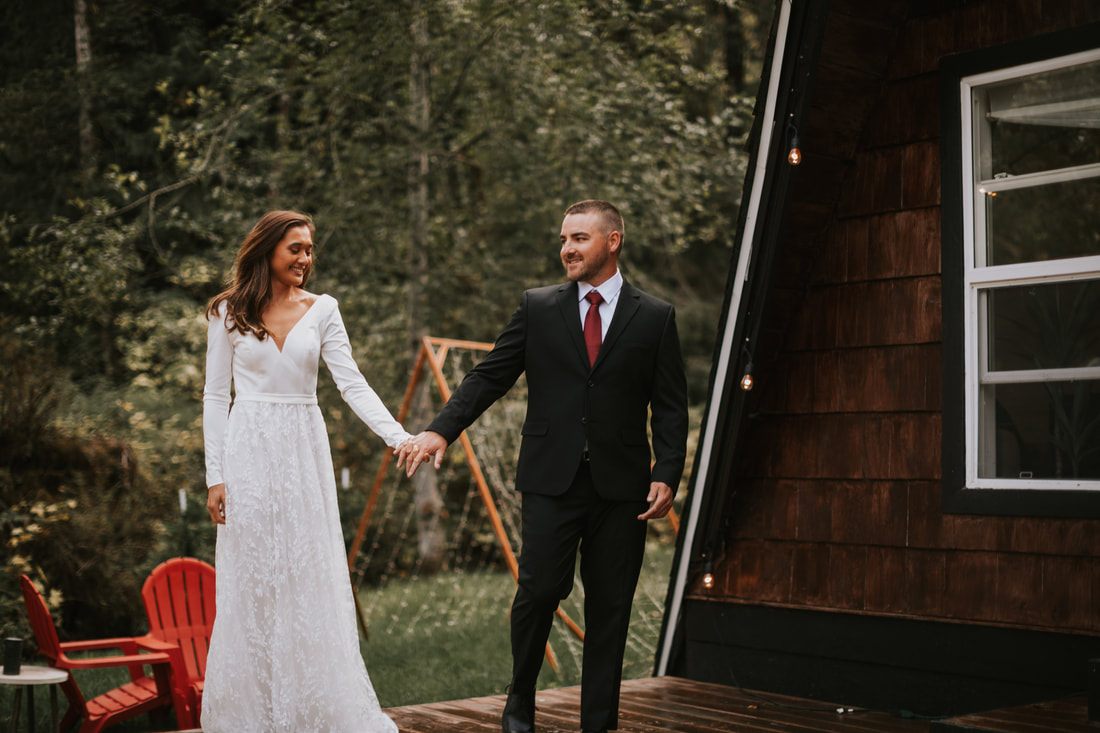 Wide shot of the newlyweds walking along the Skykomish River