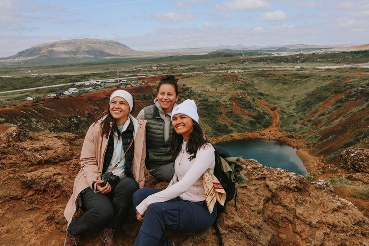 Women gathered under an Icelandic waterfall