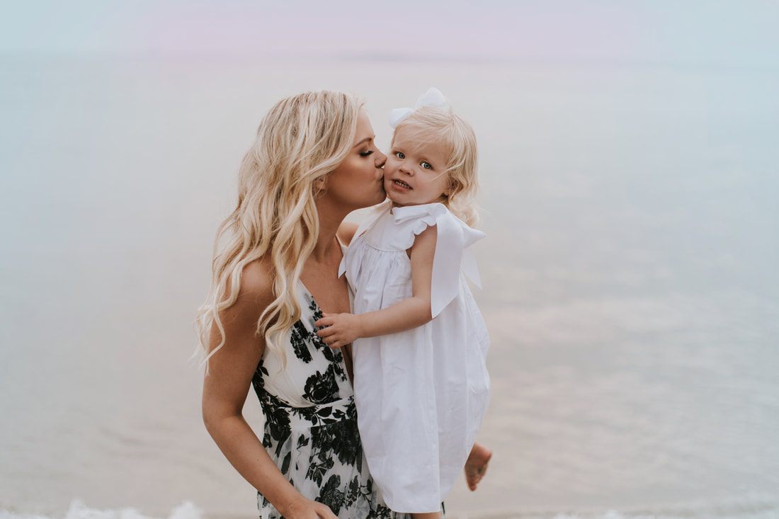 Liz and Aubrey walking along the sand during their sunset beach session