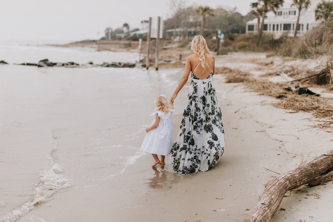 Liz and Aubrey walking hand in hand along the empty winter beach