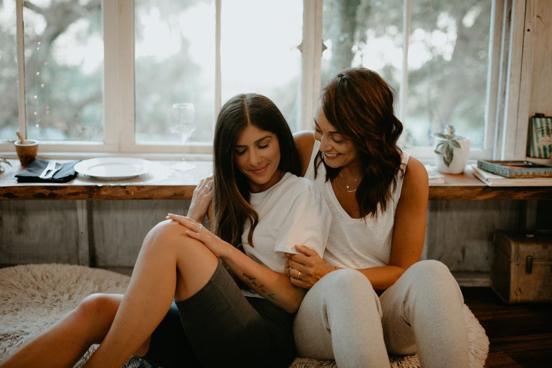 Francesca and Nicole laughing together on the treehouse porch after their proposal