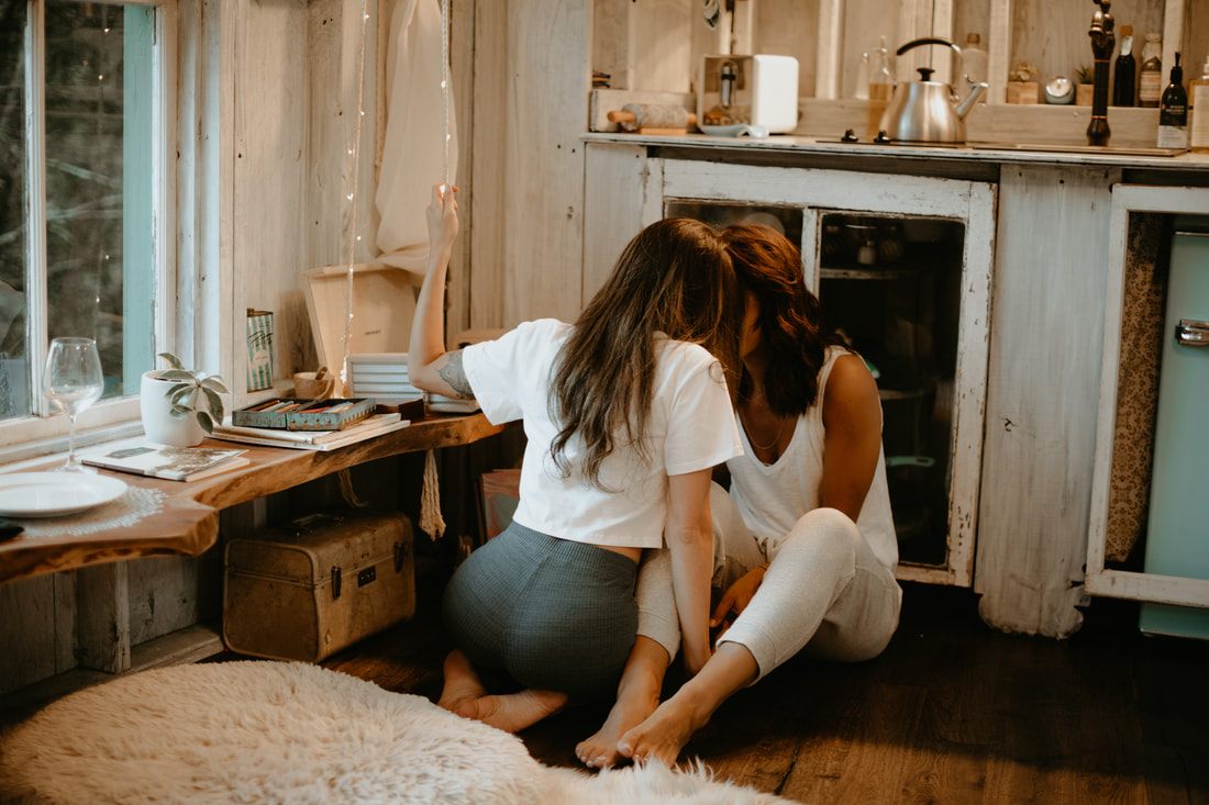 Francesca and Nicole embracing outside the whimsical Bolt Farm treehouse
