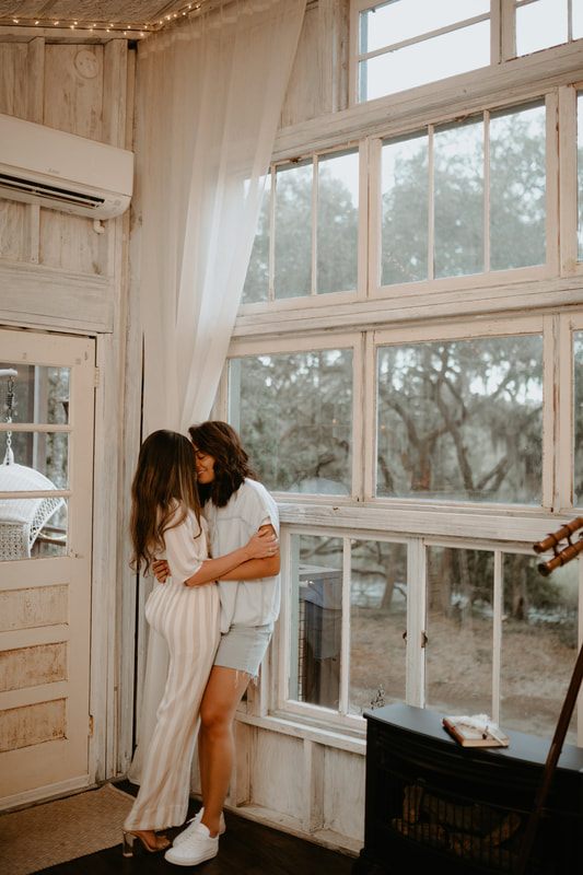 Engaged couple sharing a champagne toast at their treehouse engagement session