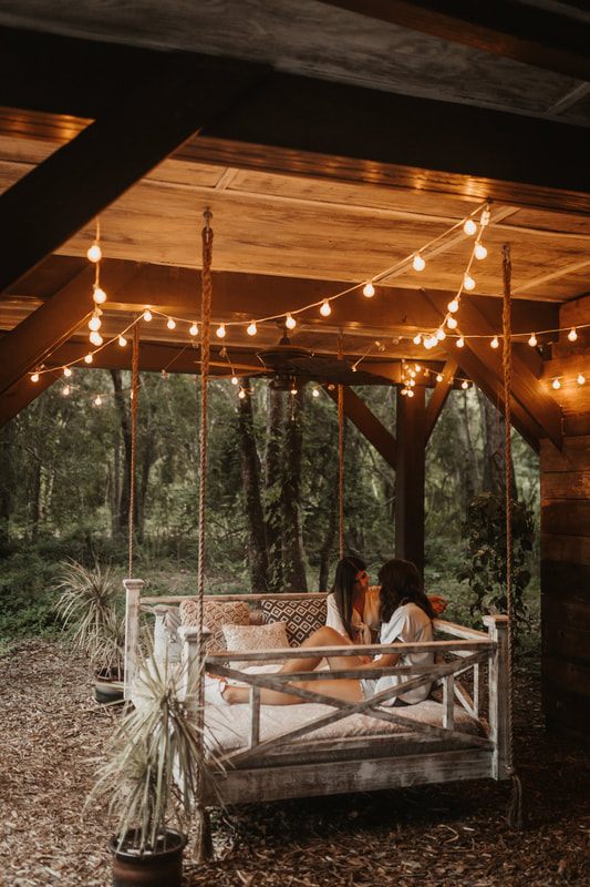 Francesca and Nicole laughing together on the treehouse porch after their proposal