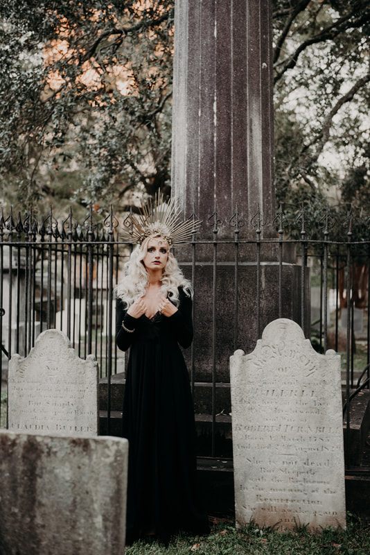 Model in Halloween-themed styling standing in a historic cemetery