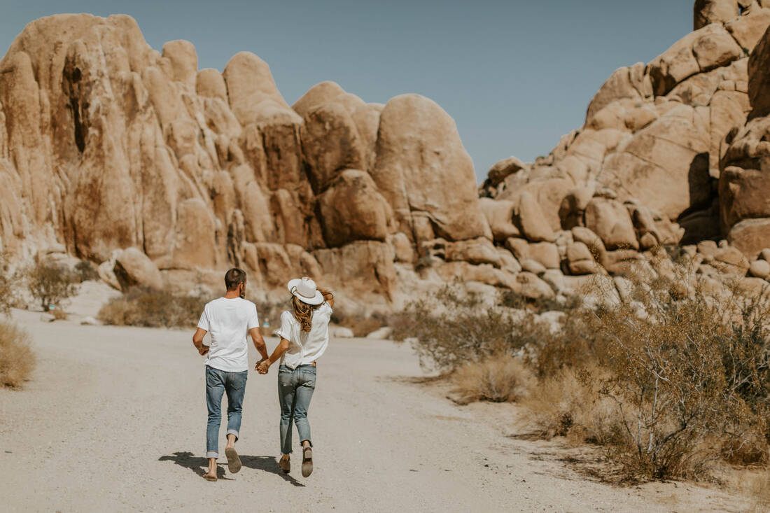 The couple sitting atop large granite boulders in Joshua Tree National Park