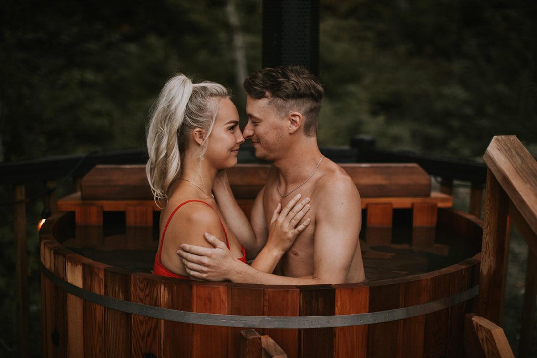The couple relaxing together in the outdoor hot tub at the PNW cabin
