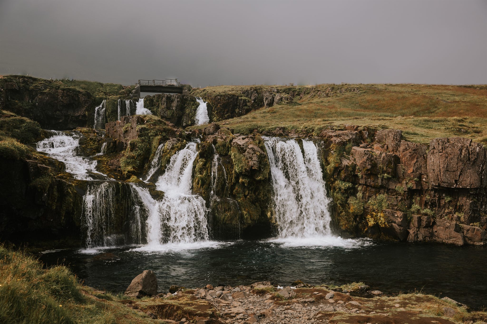 Kirkjufellsfoss waterfall under grey Icelandic sky, photographed on a women's adventure retreat in Iceland