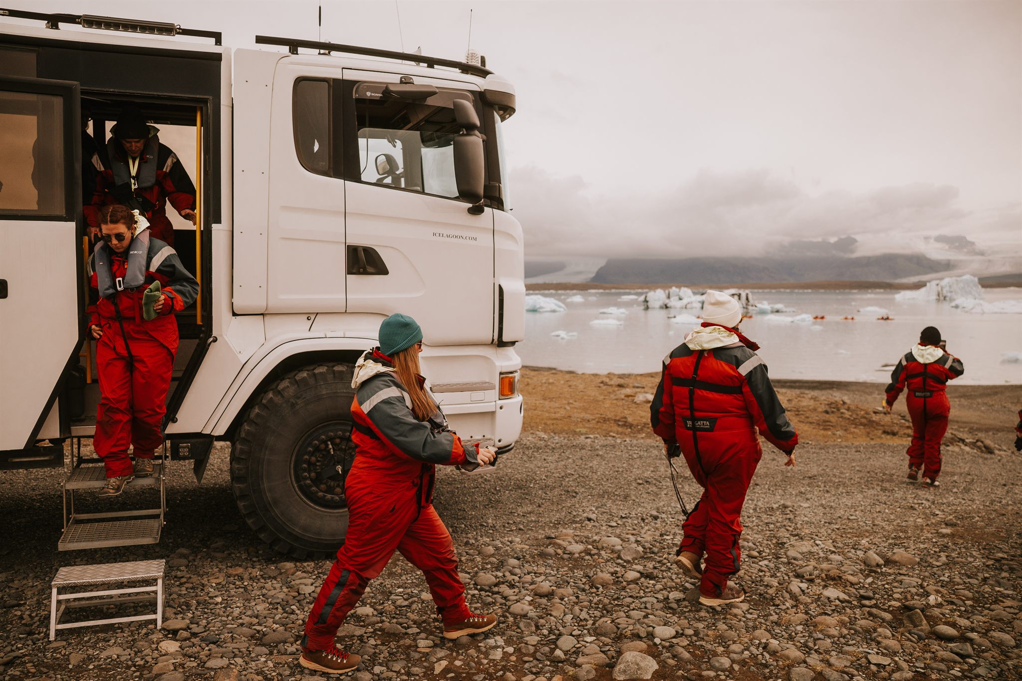 Women in red flotation suits boarding the amphibious boat at Jokulsarlon glacier lagoon on an Iceland women's adventure retreat
