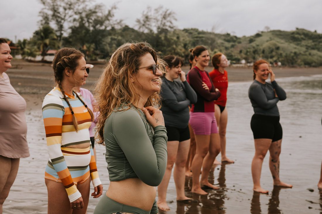 Group yoga pose on the beach during the Cambutal women's retreat
