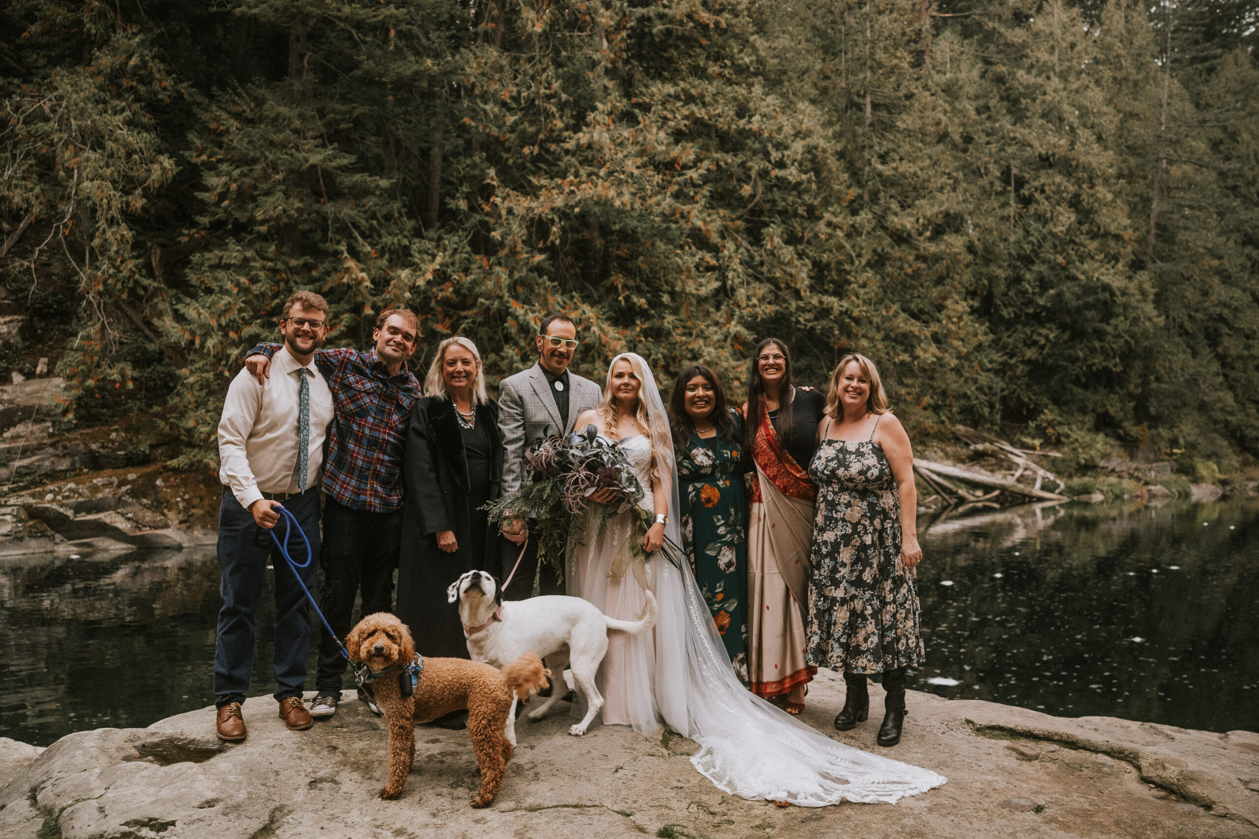 Justine and Zack with their guests and two dogs on the rocks after the ceremony