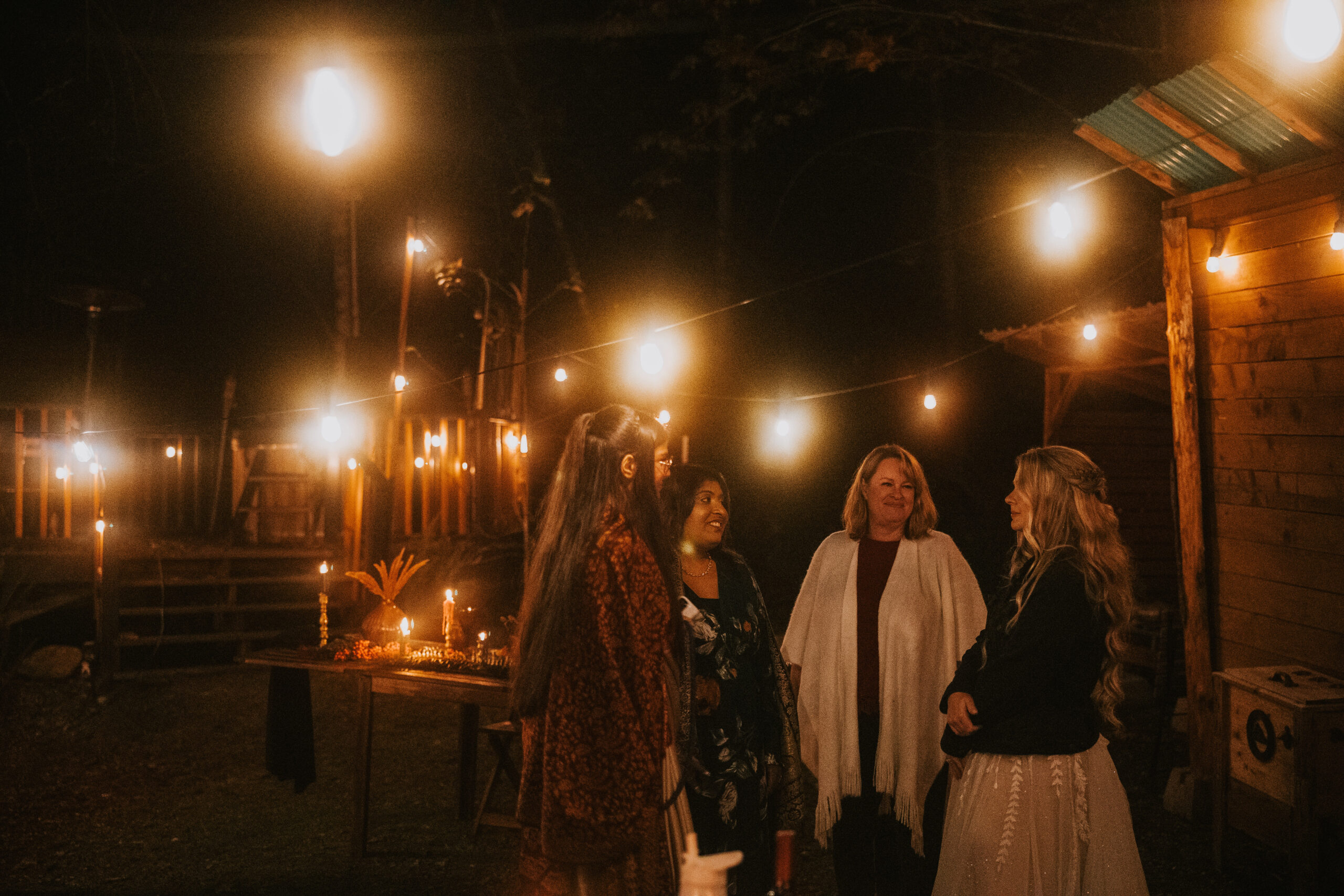 Four of the guests talking together under the lights after dinner