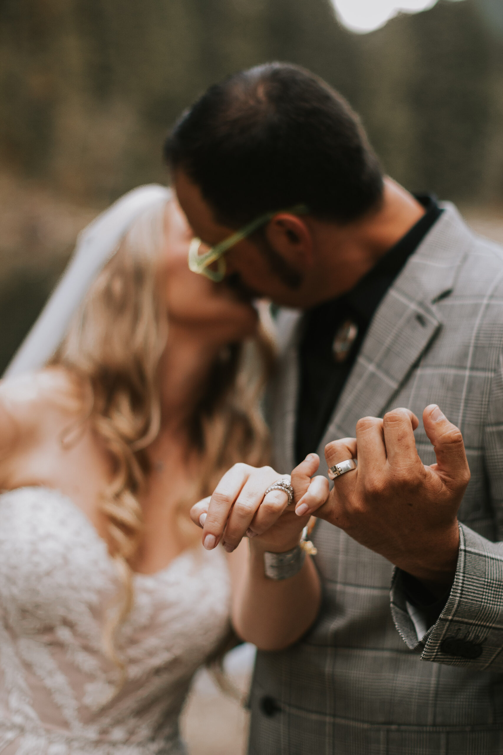 Close view of Justine and Zack's hands and new wedding bands as they lean in to kiss