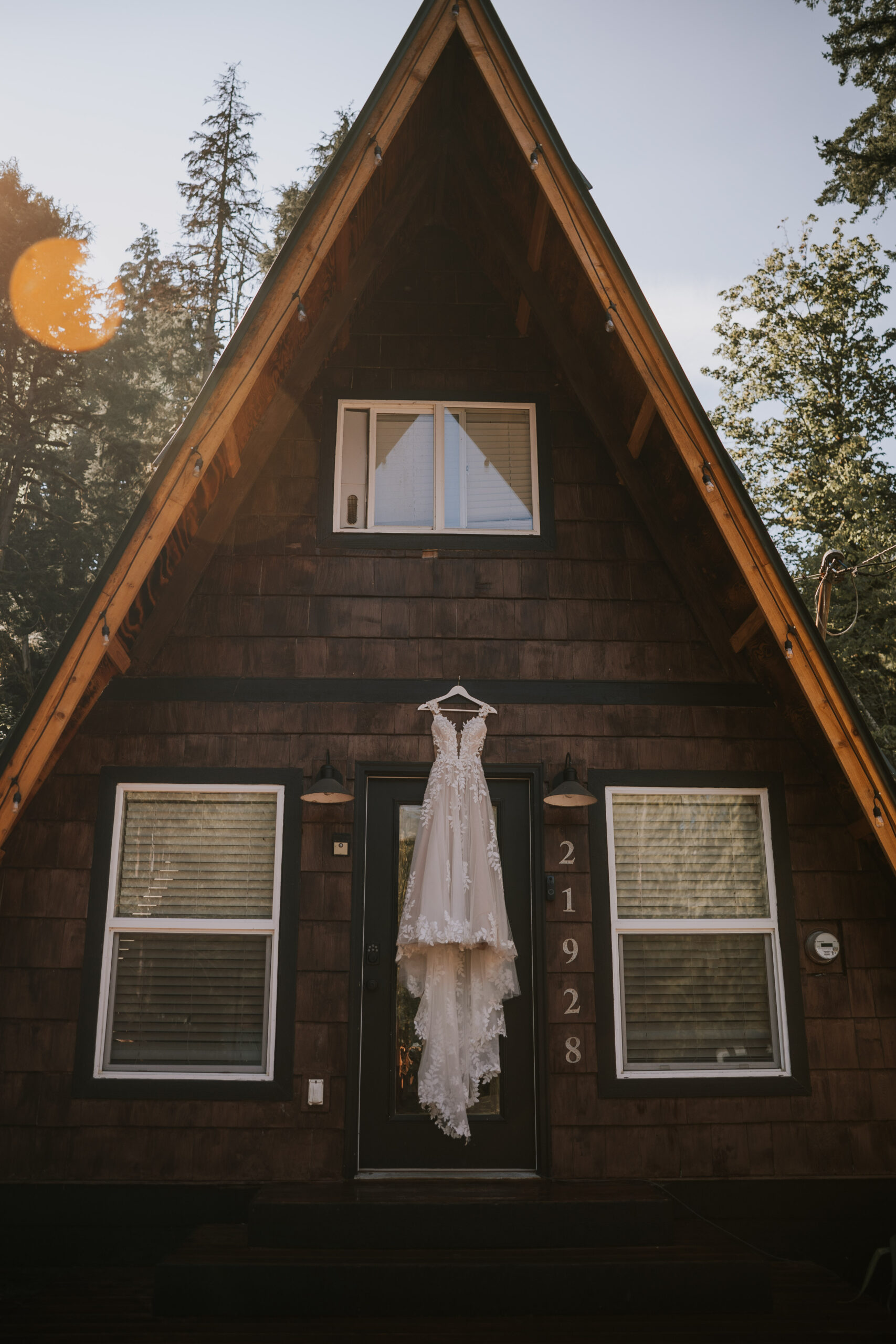 Morgan's lace wedding dress hanging on the front of the A-frame at That PNW Cabin