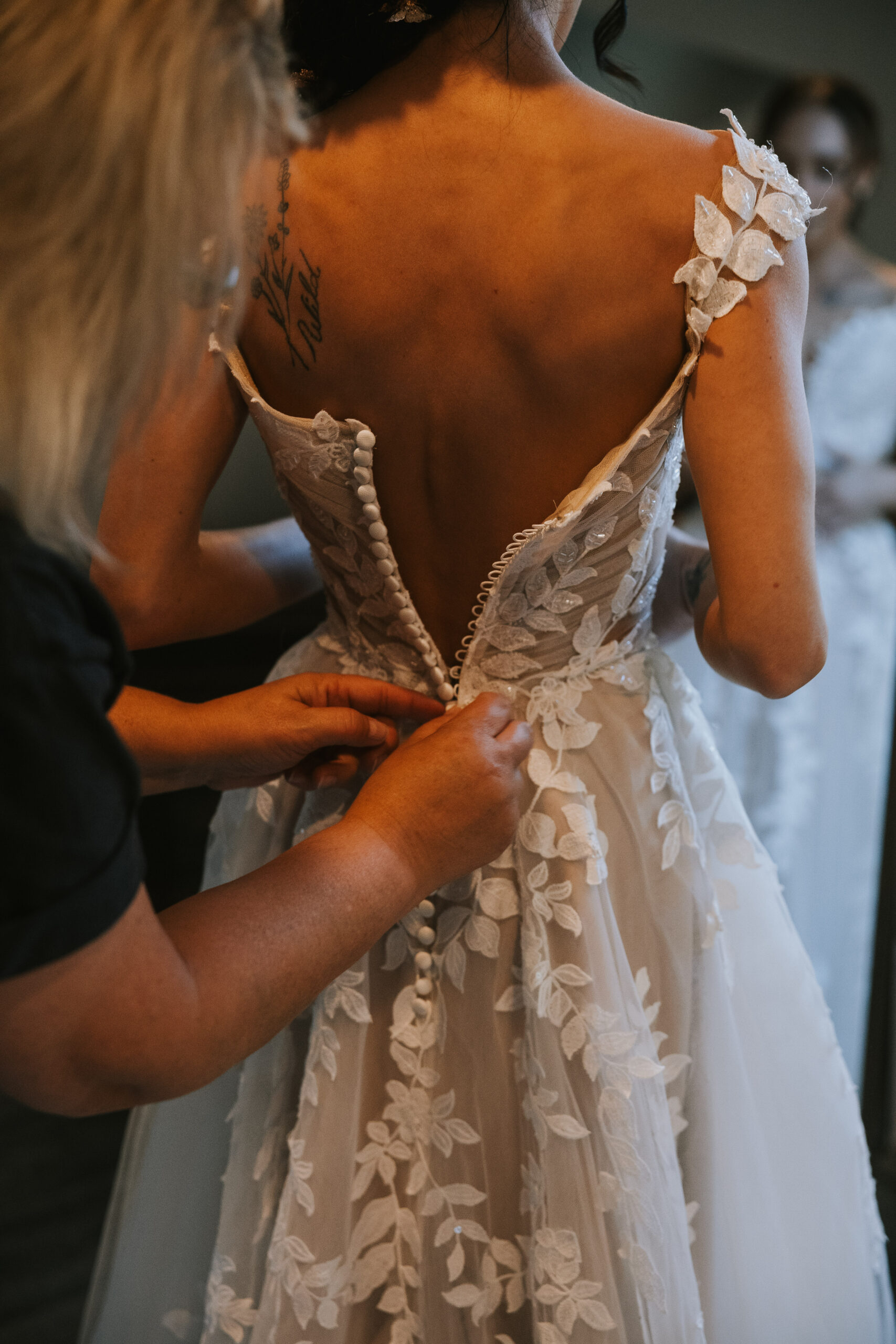 Buttoning the back of Morgan's lace gown while she gets ready