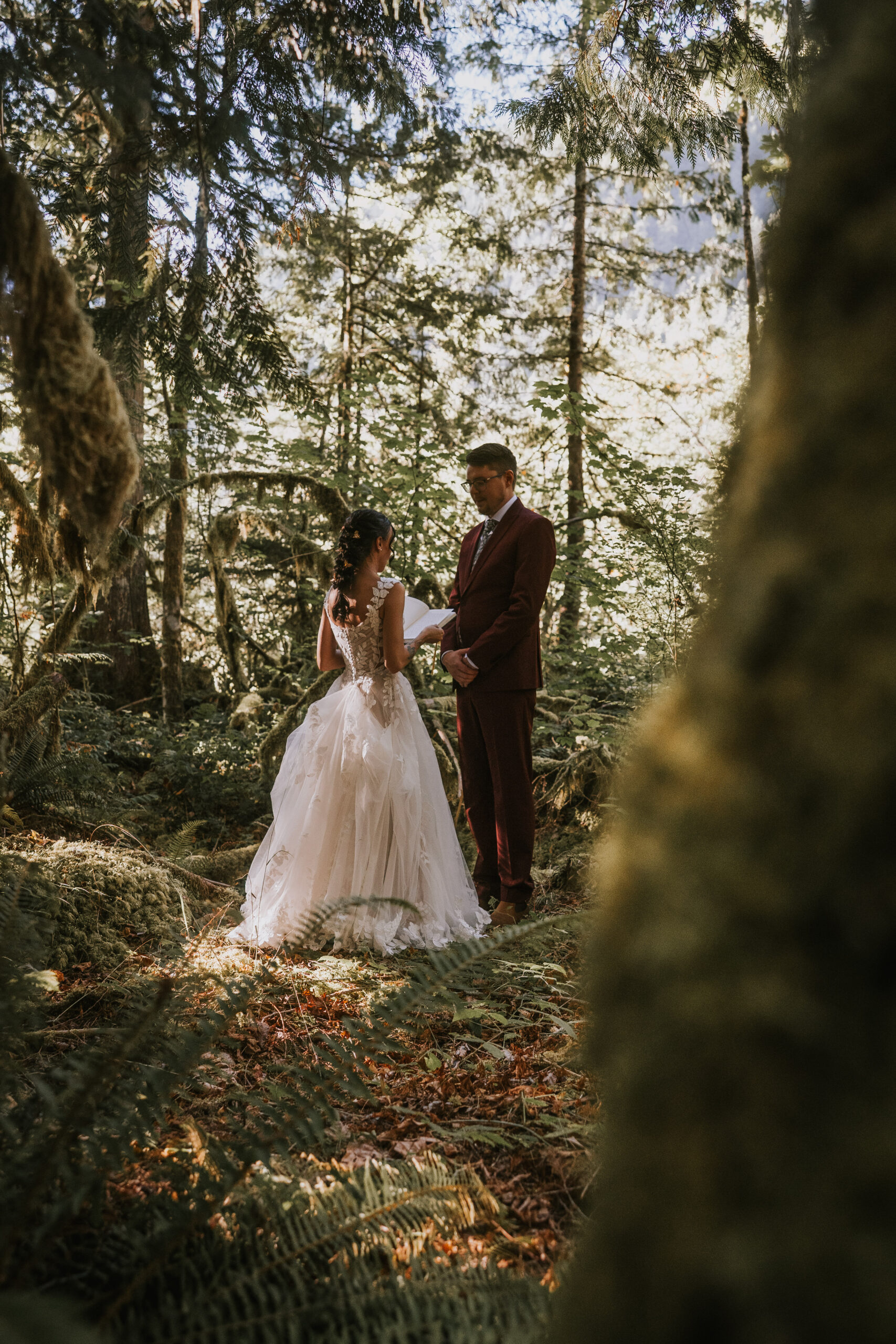 Brandon and Morgan holding hands among the ferns in the forest