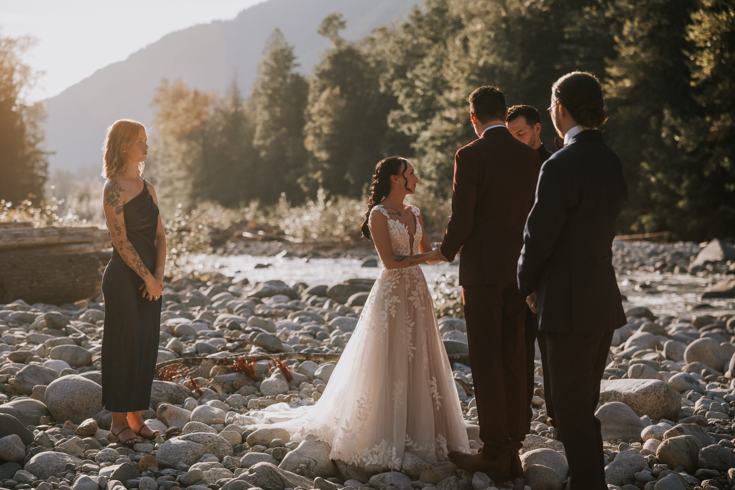 Morgan and Brandon holding hands during their vows on the riverbed