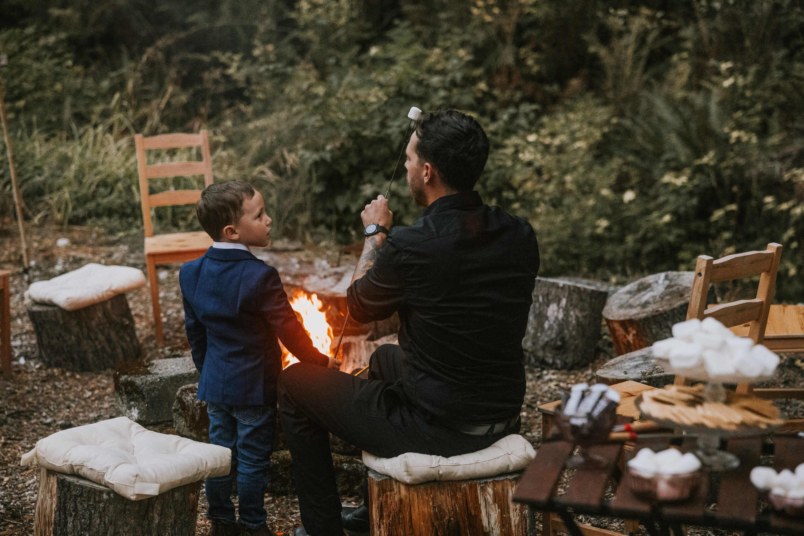 Brandon roasting marshmallows with his son at the fire pit