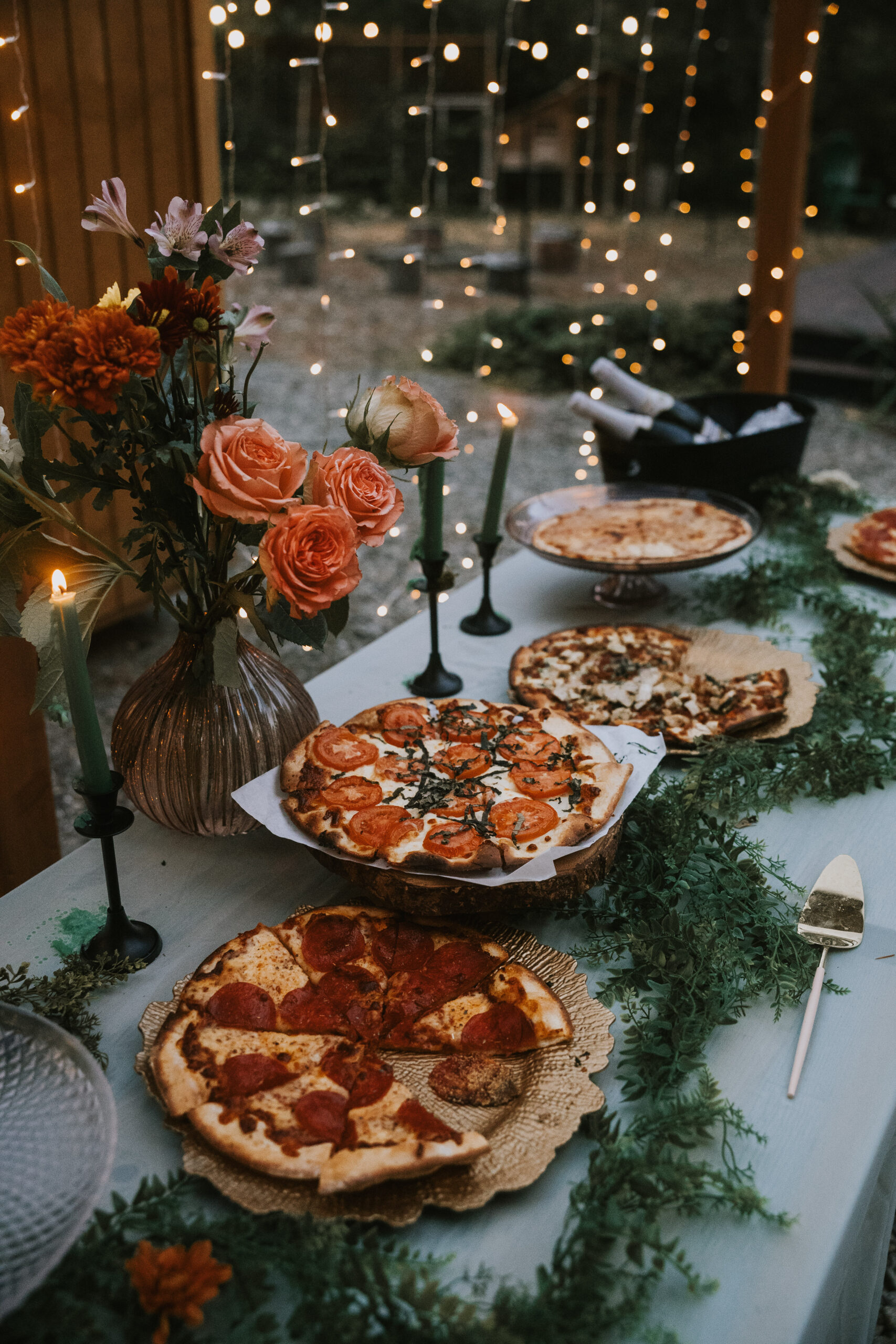 Pizzas served on the dinner table with candles and autumn flowers