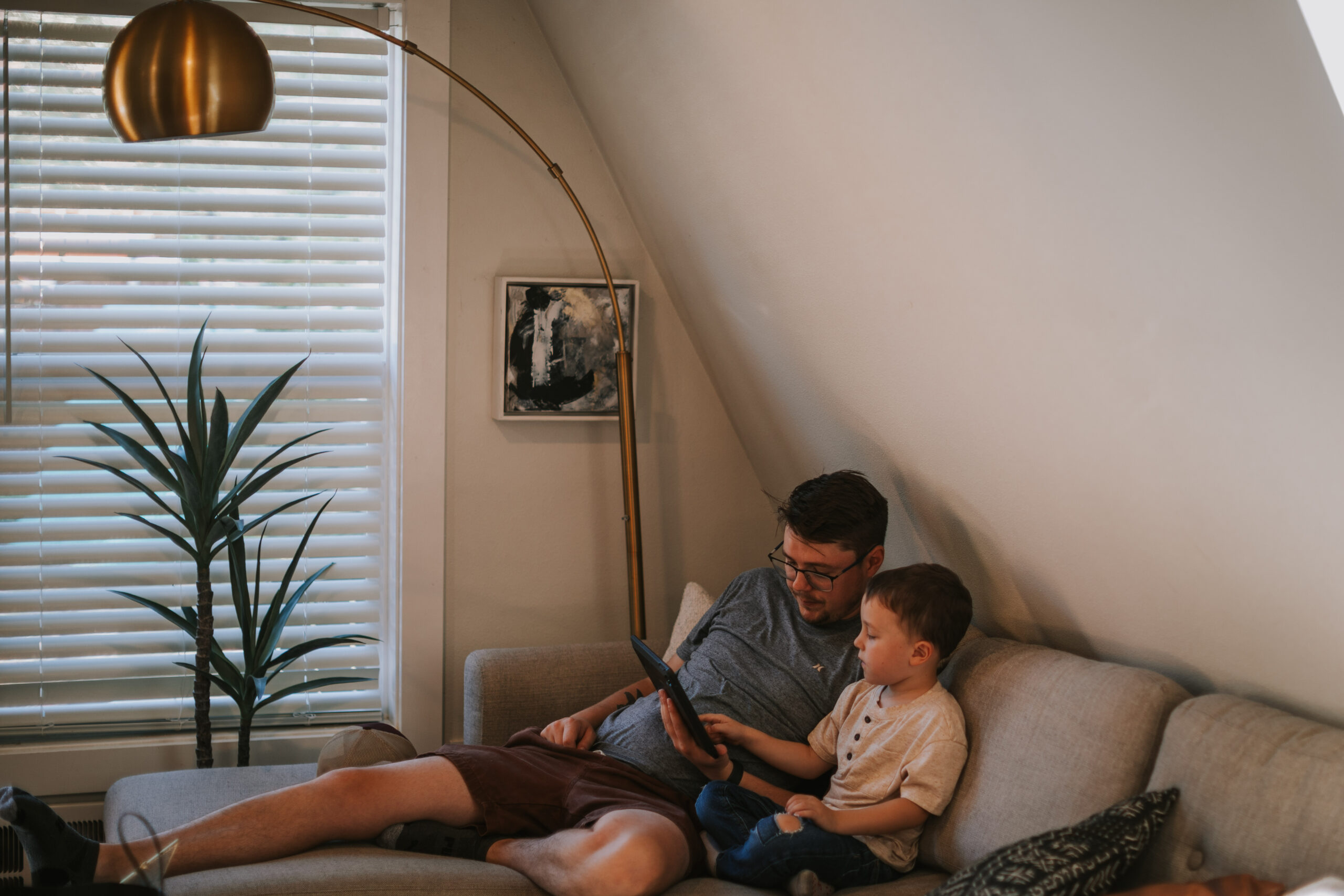Brandon reading on the couch with his son inside the cabin