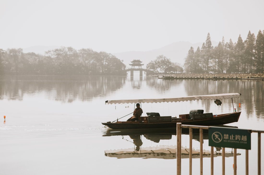 Misty morning view over Hangzhou's West Lake with pagodas in the distance