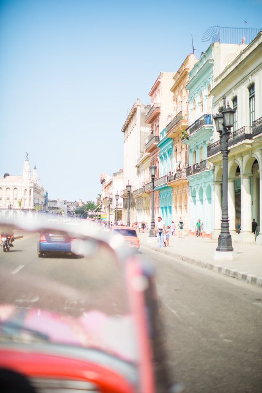 Brightly painted vintage American car parked on a colorful street in Havana, Cuba